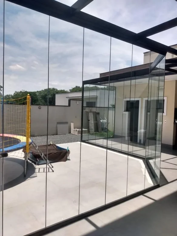 Cortina de cristal apilable en vidrio templado Blindex - sistema sin rodamientos en terraza Neuquén
